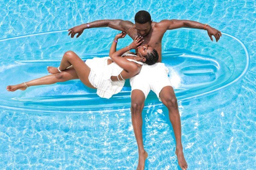 Two people floating on an inflatable ring in a swimming pool. 3