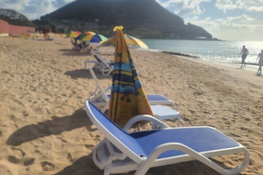 A beach with lounge chairs and umbrellas. 4
