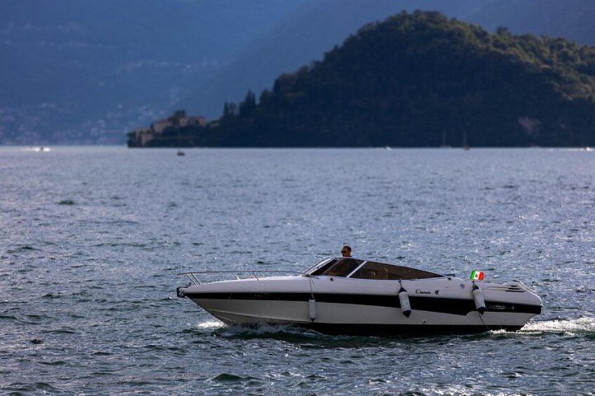 A motorboat on a calm lake with a mountainous landscape in the background. 3