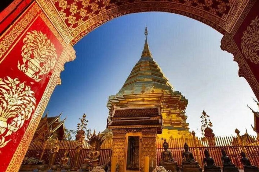 Een tempel met een gouden spits, rijke rode en gouden versieringen, en een strakblauwe lucht. 3