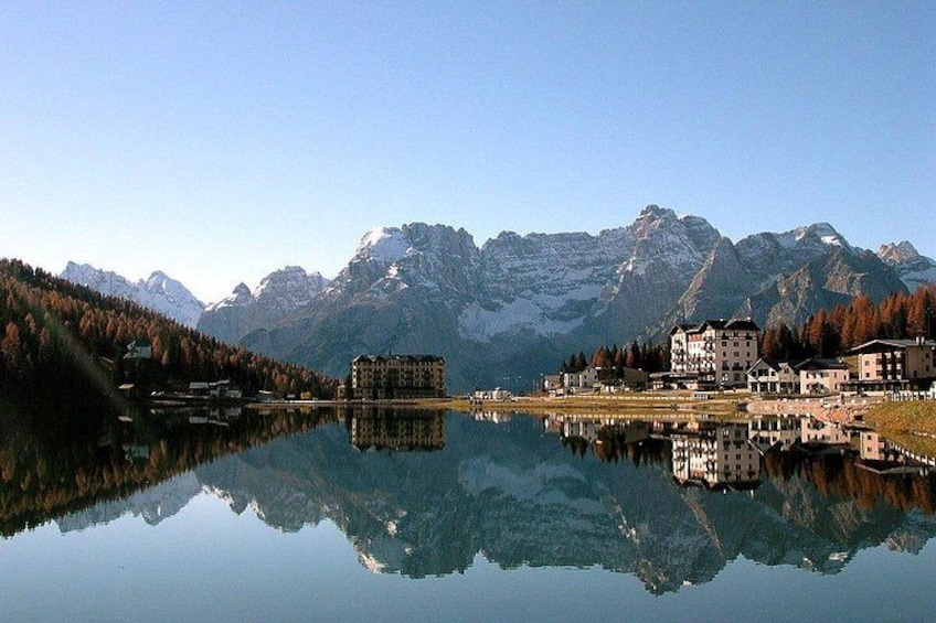 Un lago tranquillo che riflette edifici e montagne. 2