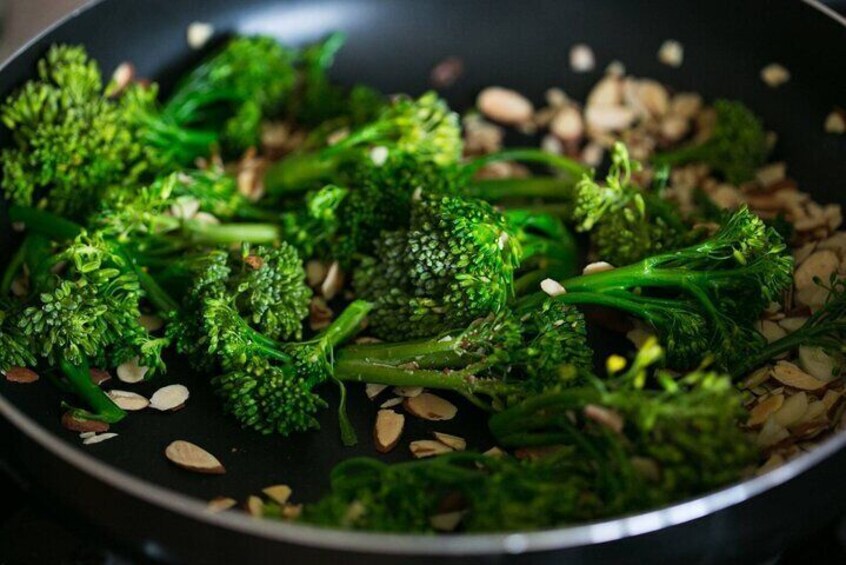 A pan with cooked broccoli and almonds. 2