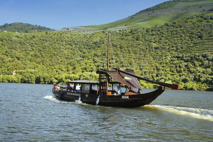 A boat with passengers on a river surrounded by lush green hills. 2