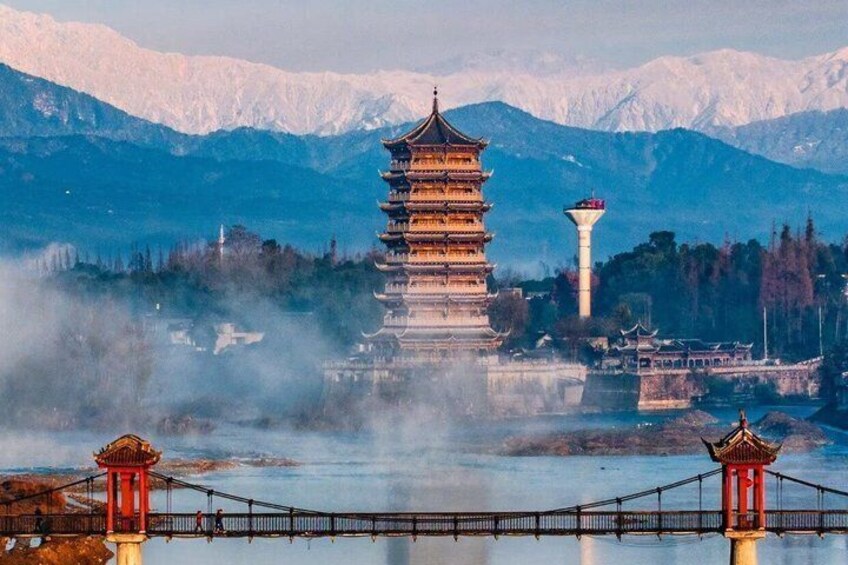 Una pagoda tradicional de varios niveles con un puente en primer plano y montañas al fondo. 5