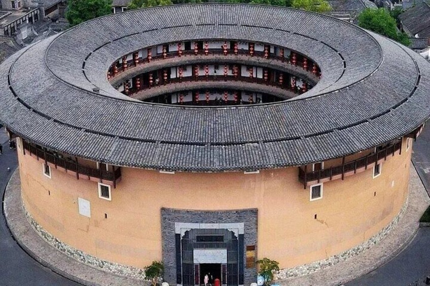A circular building with a tiled roof and a central courtyard. 1