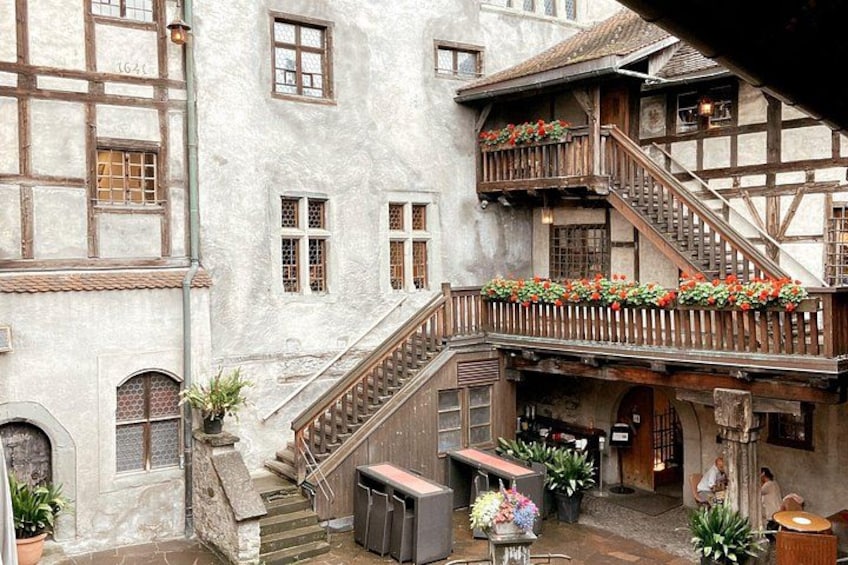 Une cour intérieure européenne traditionnelle, avec un escalier en bois, des jardinières et des murs en pierre. 3