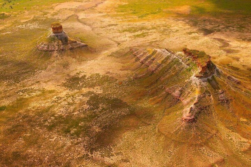 A landscape with distinct geological formations and a small body of water. 5