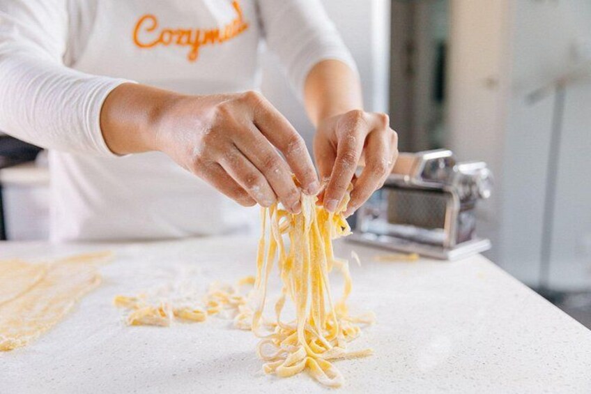 A person making pasta on a kitchen counter. 1