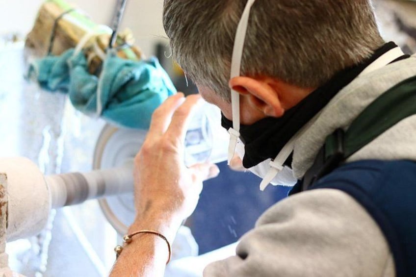 Una persona con una mascherina e una fascia, che opera una macchina. 2