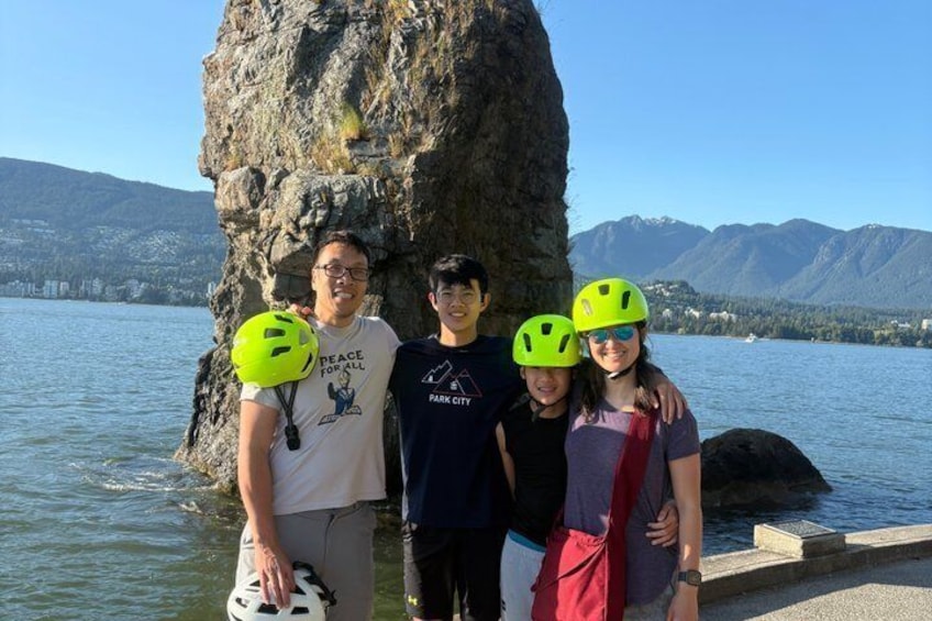 A group of people standing by a lake with mountains in the background. 4