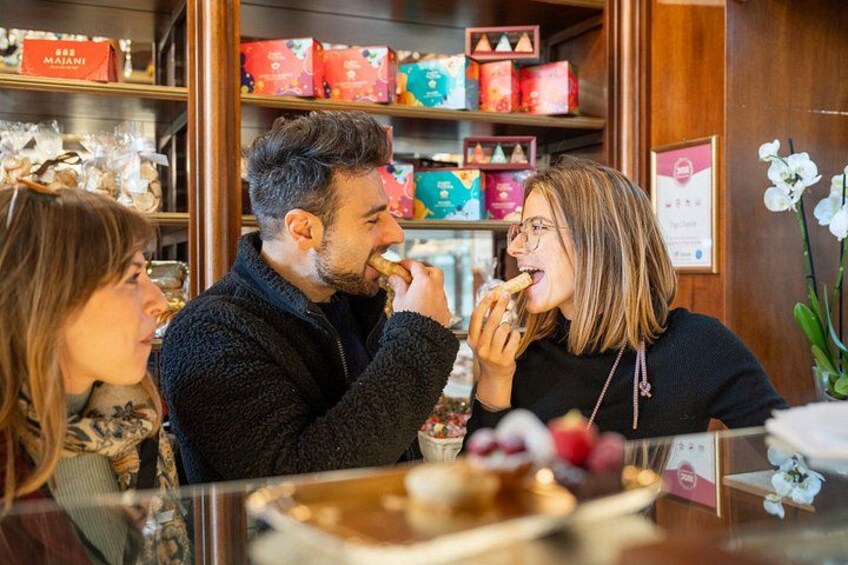 Una persona comiendo en la barra, con una variedad de productos envasados al fondo. 1