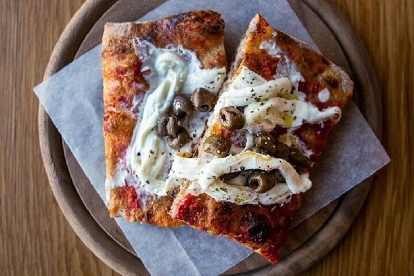 Two slices of pizza with toppings on a wooden plate. 4