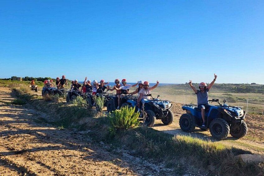 A group of people on ATVs on a dirt path with a clear sky. 1