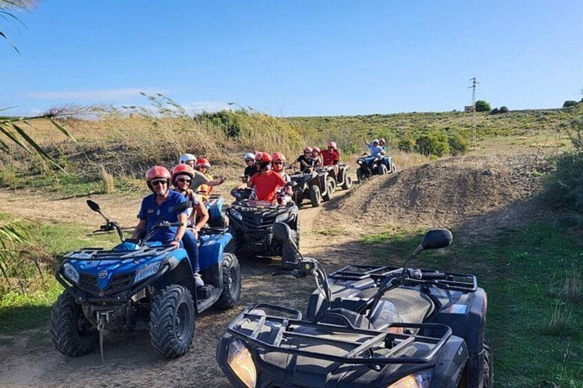 A group of people on ATVs on a dirt path in a hilly area. 3