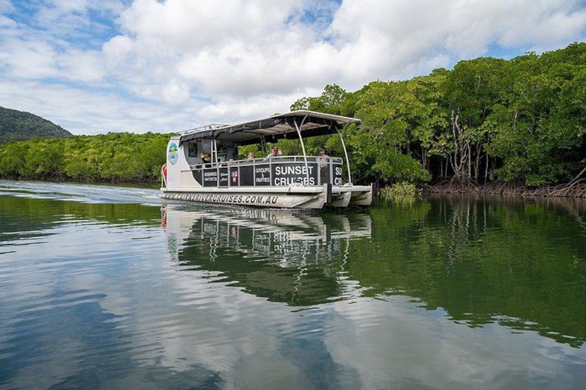 A river cruise boat with 'SUNSET Cruises' branding, surrounded by lush greenery and calm water. 4