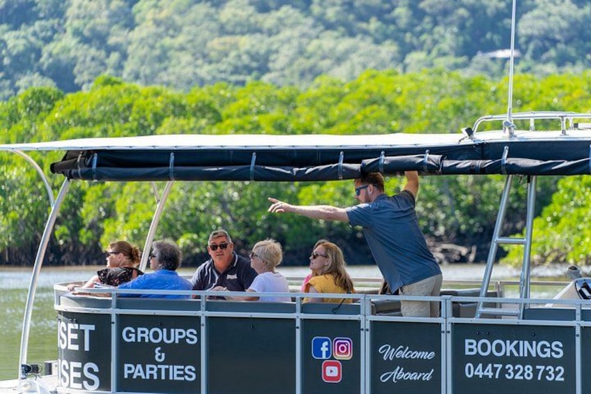 A boat with people on board, a canopy, and a backdrop of greenery. 5