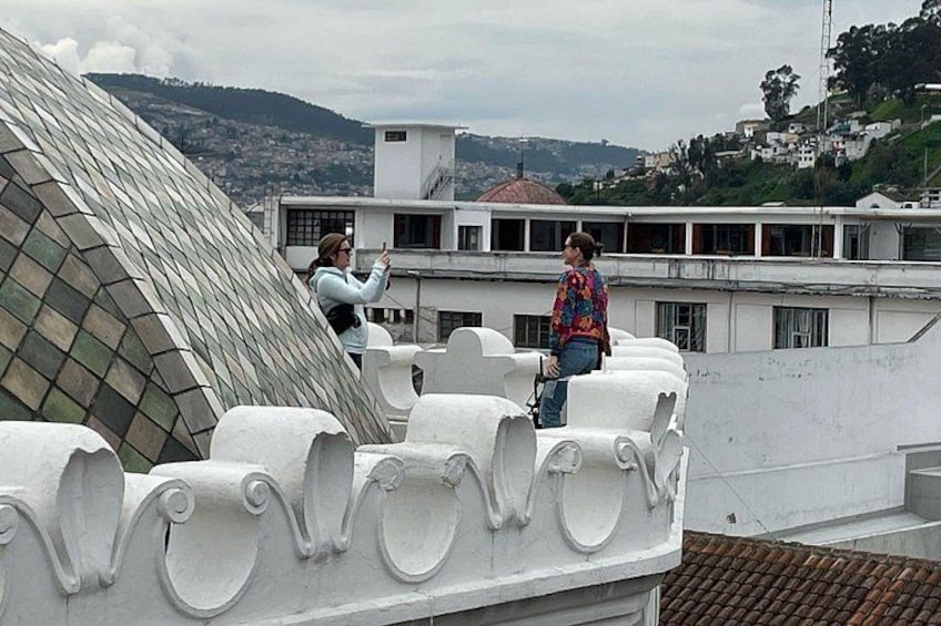 A person taking a photo of a building's roof with a unique geometric design. 3
