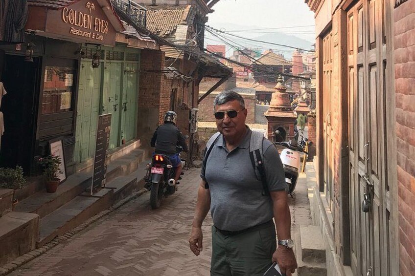 A narrow street with a restaurant named 'Golden Eyes' on the left and a person walking with a backpack. 3