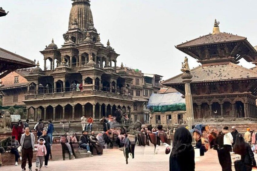 A historical building with intricate architecture, a large open courtyard, and people walking around. 4