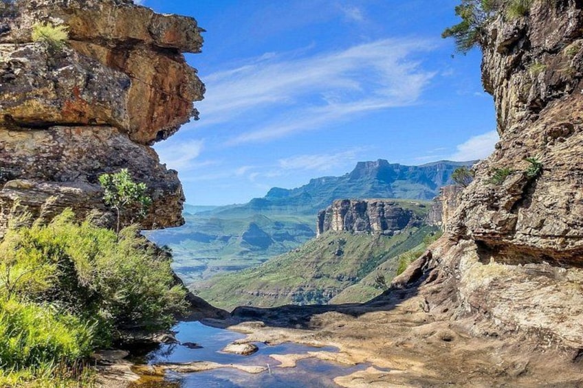 A canyon with steep rock formations, a river, and distant mountains. 3