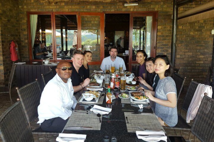 A group of people dining at an outdoor restaurant with brick walls and large windows. 5