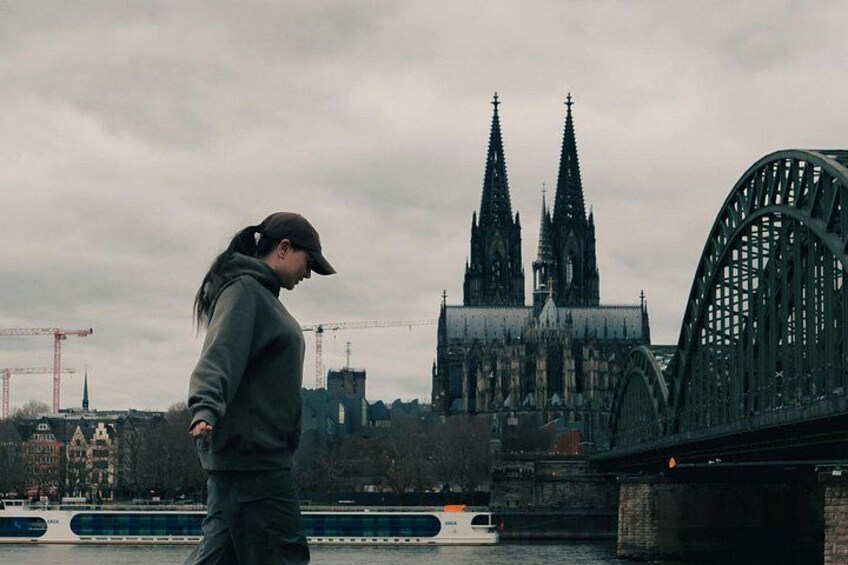 A person walking on a bridge with a gothic cathedral in the background. 4