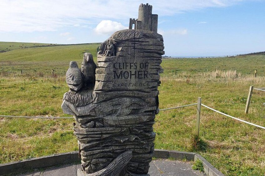 Een stenen monument met gravures en de tekst 'Cliffs of Moher Experience'. 3