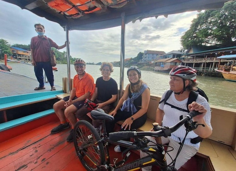 A group of people on a boat with a bicycle. 4