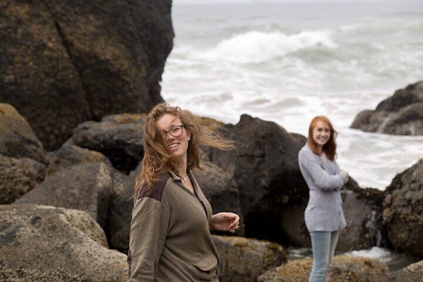 Two people standing on rocky terrain near a body of water. 2