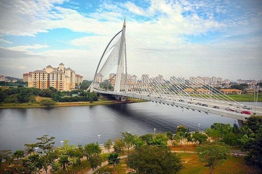 A cable-stayed bridge over a river, surrounded by greenery and residential buildings. 3