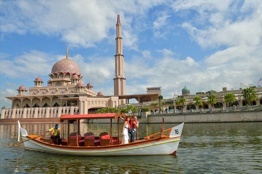 A boat with passengers, a mosque with domes and a minaret, and a clear sky. 1