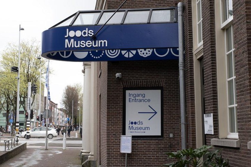 Un edificio con un cartello per il Joods Museum e una freccia che indica l'ingresso. 4