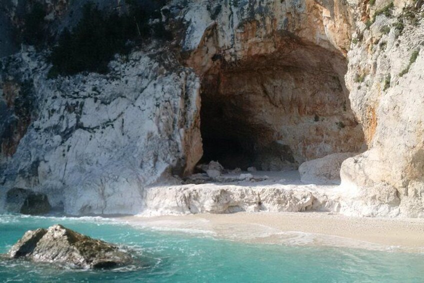 L’entrée d’une grotte côtière, avec des formations rocheuses blanches et des eaux turquoise. 2