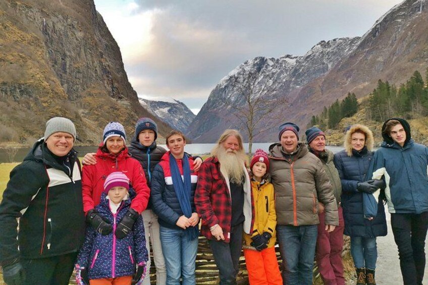 Eine Gruppe von Personen steht in einer Berglandschaft mit einem See im Hintergrund. 4