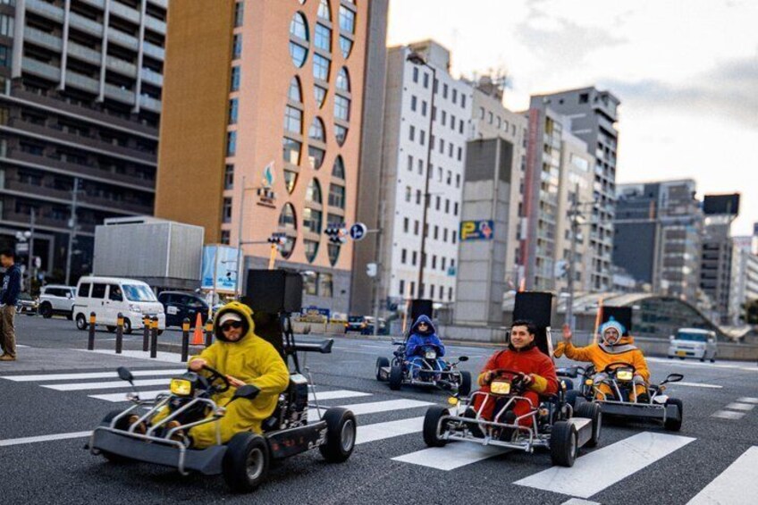 Go-karts on a city street with tall buildings in the background. 2
