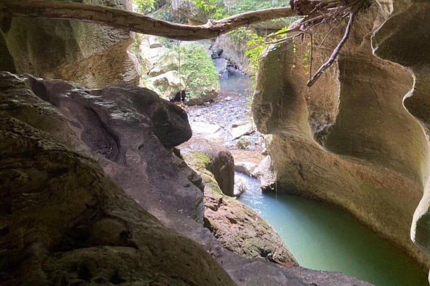 A natural rock formation with a water stream flowing through a cave. 3