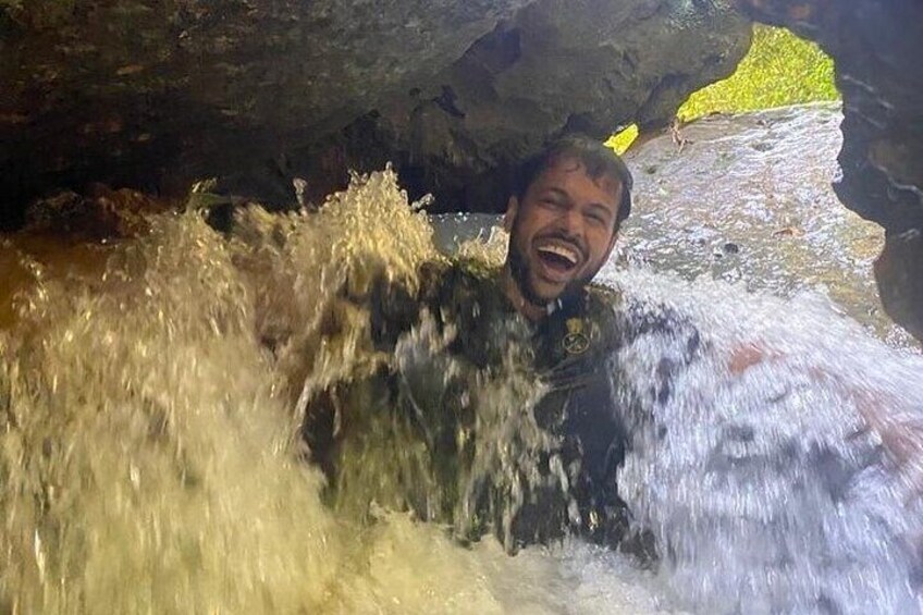 A person in a cave with water flowing around them. 2