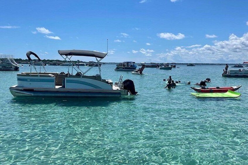 A marina with several boats, clear turquoise water, and a clear sky. 2