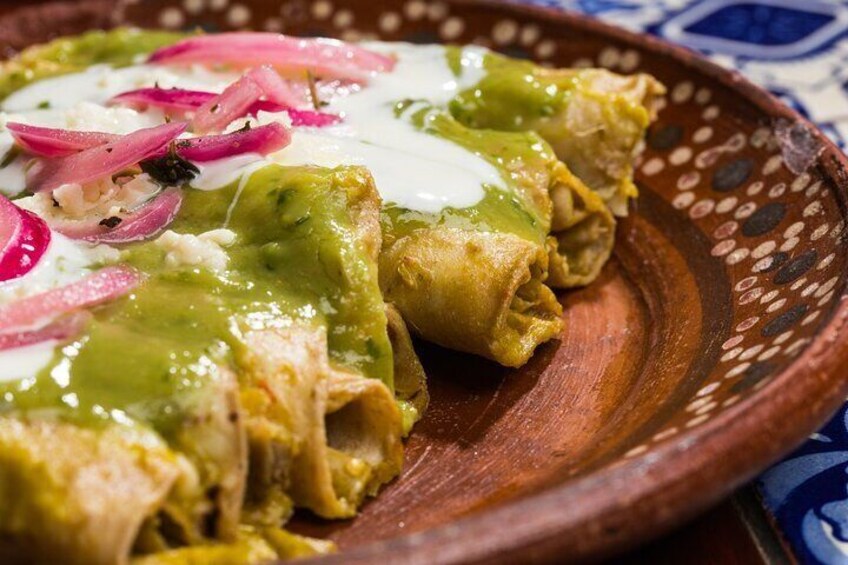 Un plato de enchiladas cubiertas de crema agria y cebollas encurtidas. 2