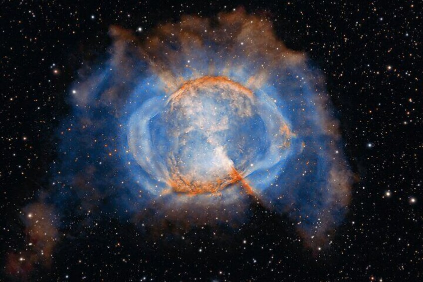 A spiral galaxy with a bright core and surrounding blue and orange hues. 1