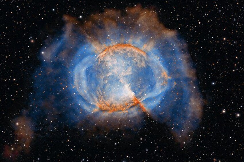 En nebula med et lyst centrum og blå og orange farver omkring. 4