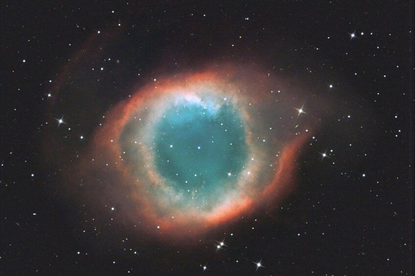 Une nébuleuse dotée d’une région centrale lumineuse et entourée de nuances rouges et bleues. 2