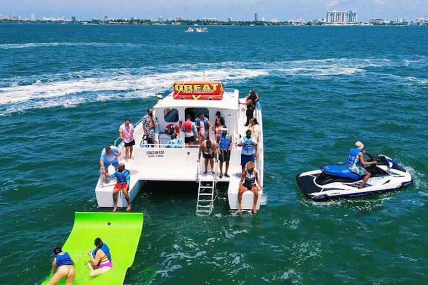 Una barca con persone a bordo e un jet ski nelle vicinanze sull'acqua. 1
