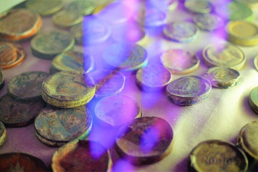 A collection of old, tarnished coins scattered on a surface. 1