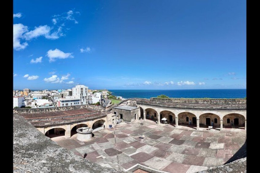 A historical fort with arched walkways and a view of the sea. 4
