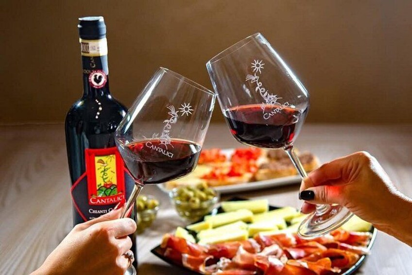 A bottle of Cantalice wine and two glasses of red wine being toasted. 1
