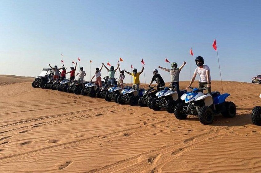 Eine Gruppe von Menschen fährt mit Quads durch eine Wüste. 2