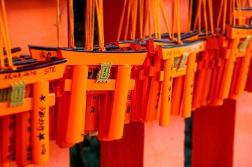 Una hilera de torii anaranjados con caracteres japoneses. 5