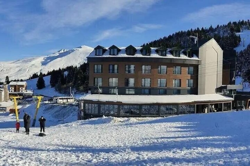 A snow-covered ski resort with a building and a mountain in the background. 5