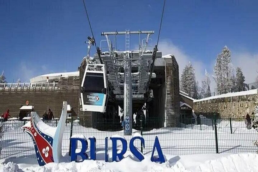 A ski lift, a snow-covered area, and a sign with the word 'RIPSA'. 2